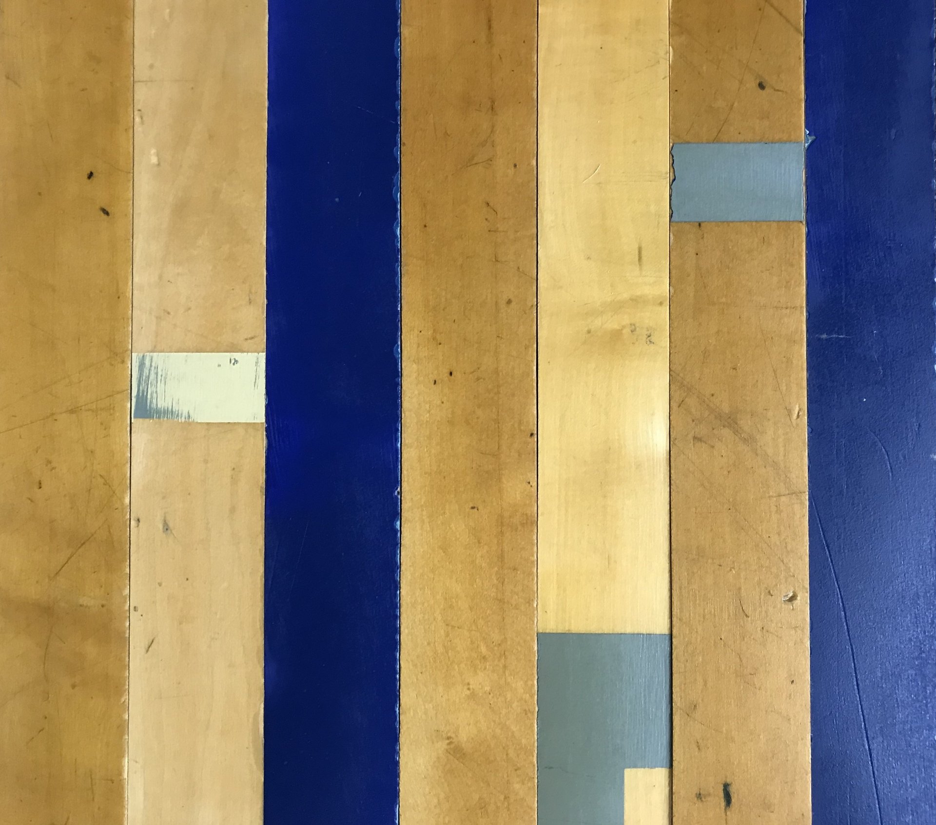 Reclaimed wood from the original Creighton University gym floor showing age, wear, and varied surface color
