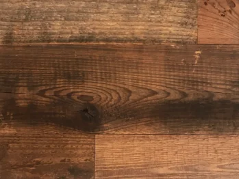 Close-up of the Wall & Ceiling Accent Plank displaying a natural wood grain, arranged in a staggered pattern with various brown shades and subtle surface imperfections.